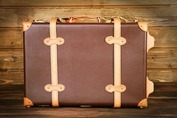 Suitcase on wooden background — Stock Photo, Image