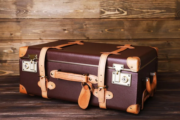 Suitcase on wooden background — Stock Photo, Image