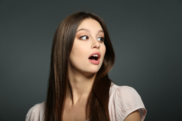 Portrait of beautiful young woman on dark background