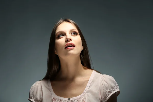 Portret van mooie jonge vrouw op donkere achtergrond — Stockfoto