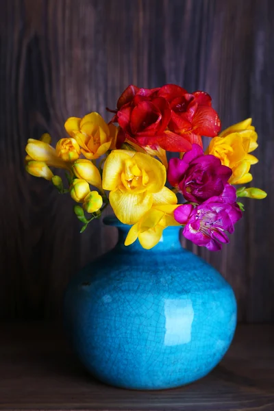 Colorful freesia in vase on wooden background — Stock Photo, Image