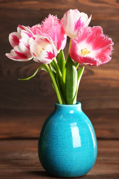 Lindas tulipas em vaso no fundo de madeira — Fotografia de Stock