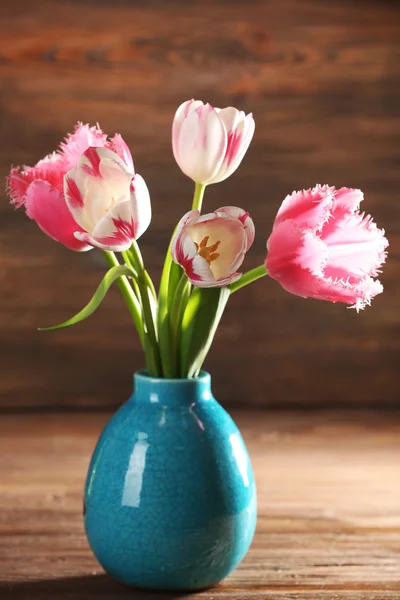 Tulipanes rosas en jarrón sobre fondo de madera — Foto de Stock