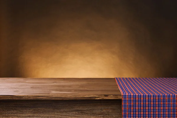 Pusty drewniany stół z serwetka i brązowym tle — Zdjęcie stockowe