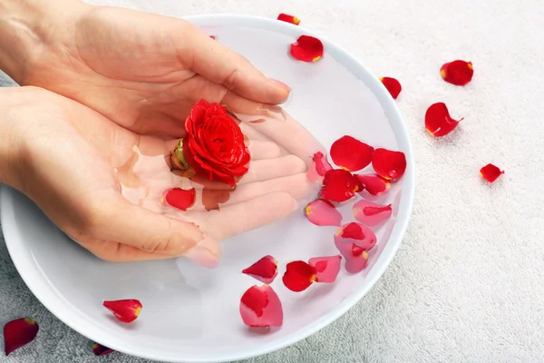 Female hands with bowl of aroma spa water on table, closeup Stock Photo