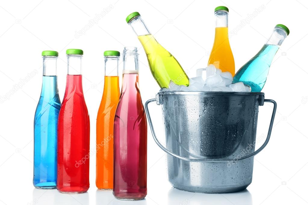 Bottles of tasty drink and metal bucket with ice isolated on white