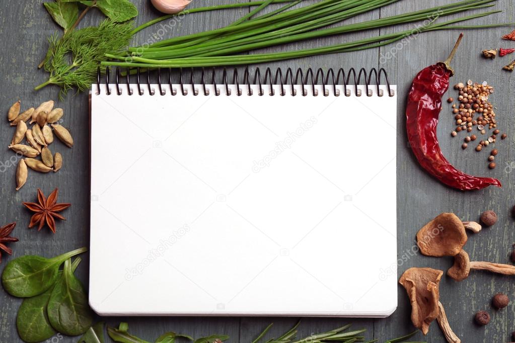 Open recipe book with fresh herbs