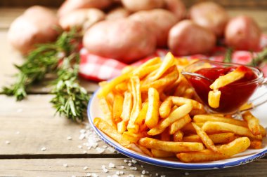 Ahşap masa arka plan üzerinde plaka üzerinde lezzetli Fransız kızartması