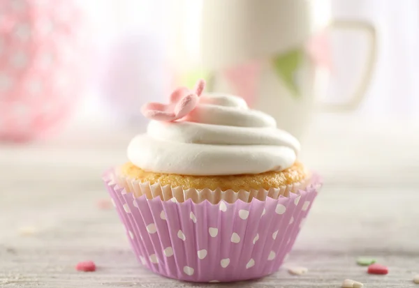 Delicioso cupcake na mesa no fundo claro — Fotografia de Stock