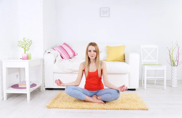 Giovane donna che fa yoga a casa — Foto Stock
