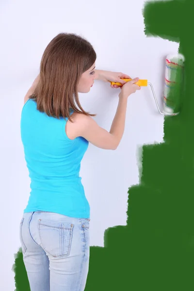 Krásná dívka barvy na zeď v pokoji — Stock fotografie