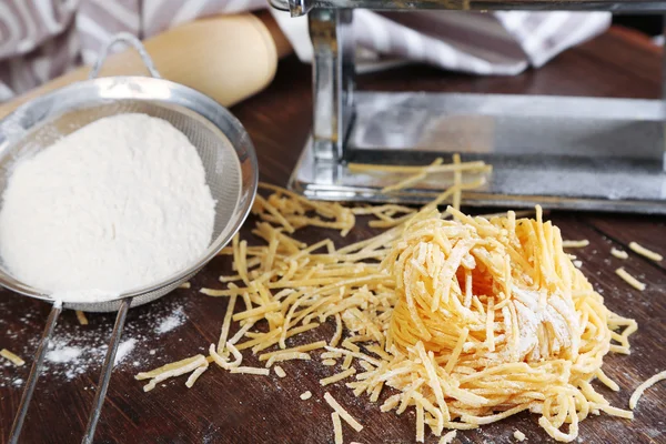 Att göra spån med pasta maskin på trä bakgrund — Stockfoto