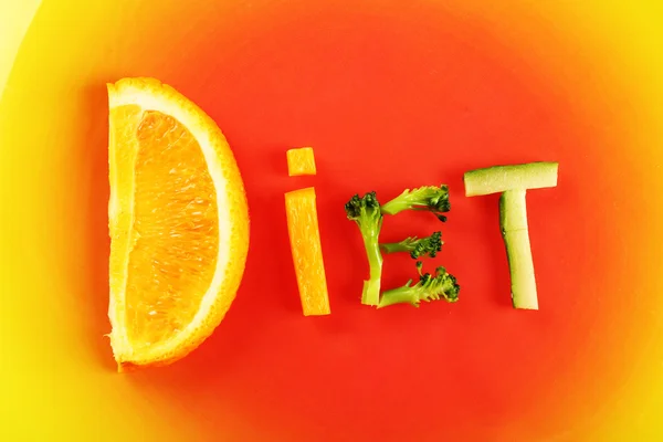 Palavra DIET feito de legumes fatiados no fundo da placa de cor — Fotografia de Stock