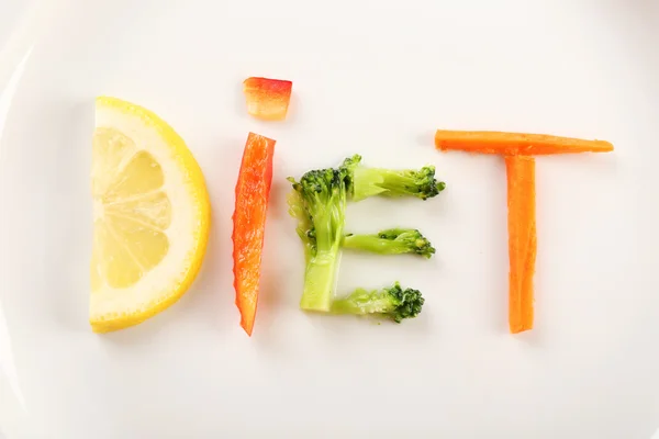 Palabra DIETA hecha de verduras en rodajas sobre fondo de plato blanco — Foto de Stock