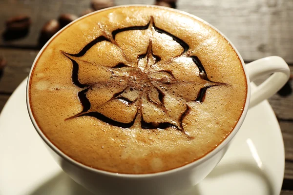 Cup 的咖啡拿铁艺术与谷物在木桌子上，特写 — 图库照片