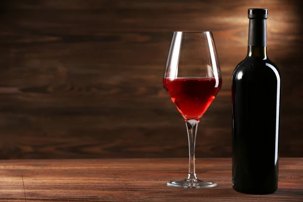 Vinho e garrafa em fundo de madeira — Fotografia de Stock