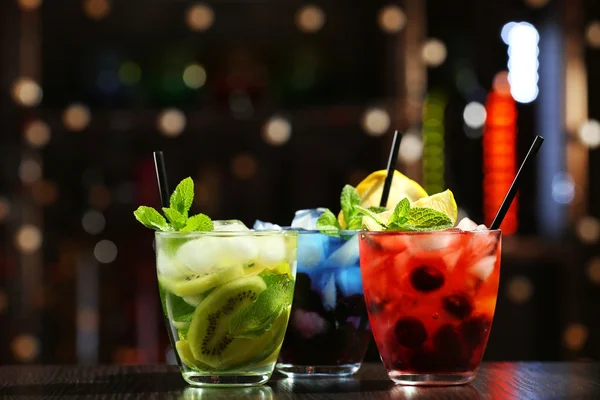 Glasses of cocktails in bar on bright blurred background — Stock Photo, Image