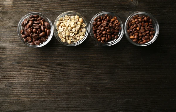 Coffee beans in saucers on wooden background — Stock Photo, Image