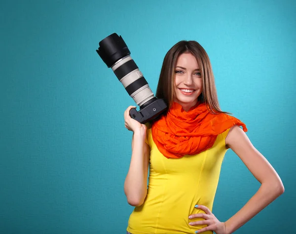 Młoda kobieta fotograf robienia zdjęć na niebieskim tle — Zdjęcie stockowe
