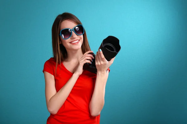 Mavi arka plan üzerinde çekim genç kadın fotoğrafçı — Stok fotoğraf