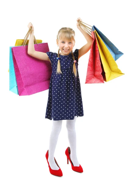 Hermosa niña en los zapatos de mamá con bolsas de compras aisladas en blanco — Foto de Stock