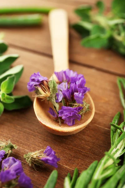 Groene kruiden en bladeren op houten tafel, close-up — Stockfoto