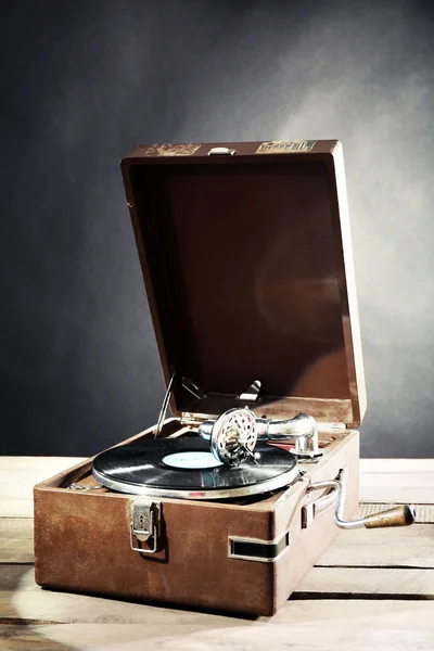 木制的桌子上深色背景上的黑胶唱片留声机 — 图库照片