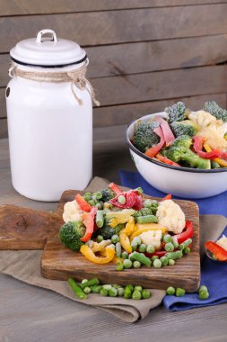 Peçeteye ahşap masa arka plan üzerinde kesme tahtası üzerinde Dondurulmuş sebzeler