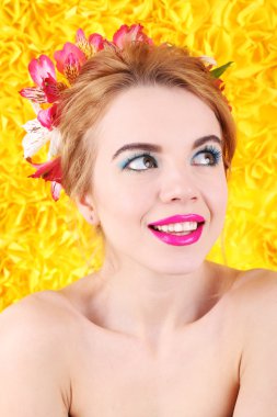 Çiçekli saç parlak sarı zemin üzerine genç kadın portresi