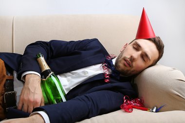 Genç adam eğlenceli kapattıktan sonra kanepede
