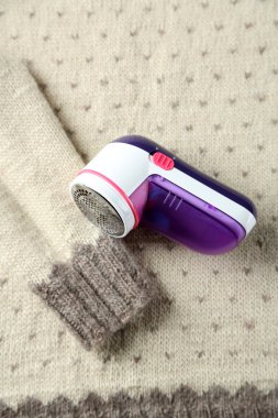 Wool shaver on wool sweater background clipart