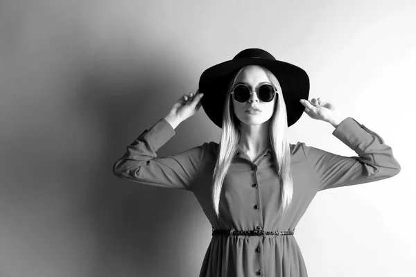 Чорно-біле фото експресивної молодої моделі з капелюхом і сонцезахисними окулярами — стокове фото