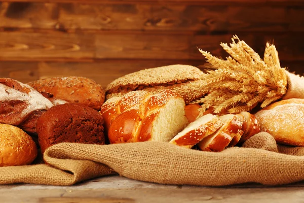 Verschiedenes Brot mit Ohren auf Holzgrund — Stockfoto