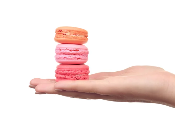 Macaroons coloridos saborosos na mão feminina isolada em branco — Fotografia de Stock