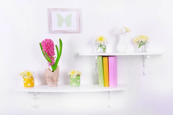 Květina na policích na bílé zdi pozadí — Stock fotografie