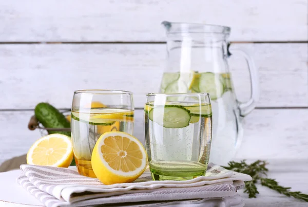레몬과 오이 나무 배경에 유리에 신선한 물 — 스톡 사진