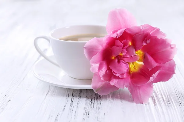 Tulipa rosa com xícara de café em fundo de madeira — Fotografia de Stock