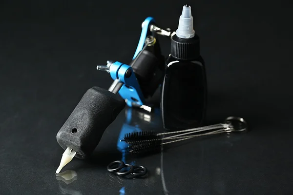 Tattoo machine en leveringen, tattoo op donkere achtergrond — Stockfoto