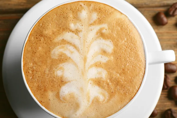 Xícara de café arte latte com grãos, close-up — Fotografia de Stock