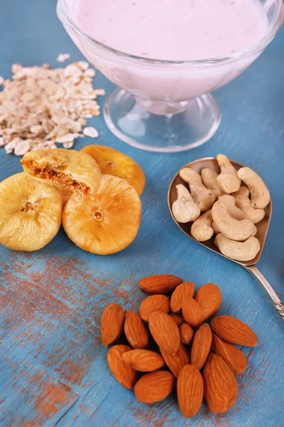 Gesundes Frühstück mit getrockneten Früchten und Nüssen auf farbigem Holzhintergrund — Stockfoto