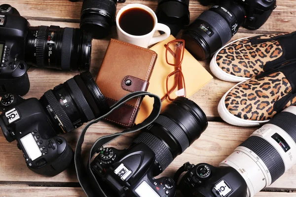 Nature morte avec des caméras modernes sur une table en bois, gros plan — Photo