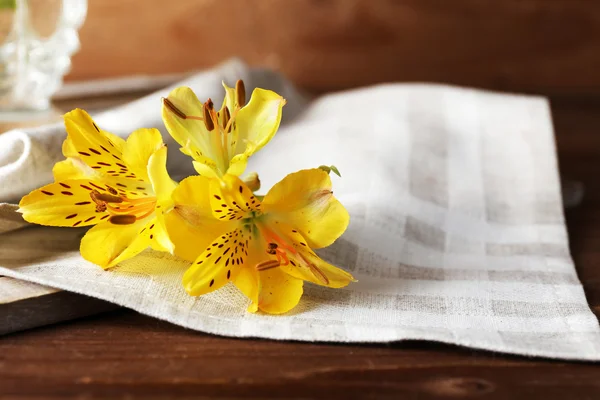 Hermosas flores de primavera en la mesa de madera con servilleta, primer plano — Foto de Stock