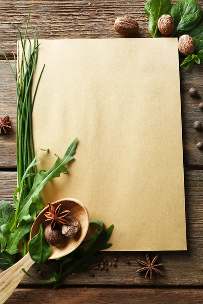 Öppna receptbok med färska örter och kryddor på trä bakgrund — Stockfoto