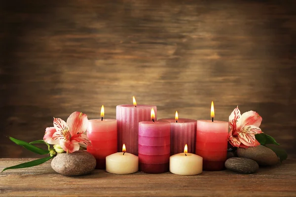 Hermosa composición con velas y piedras de spa sobre fondo de madera —  Fotos de Stock