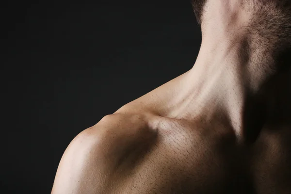 Muscolo giovane uomo su sfondo scuro — Foto Stock