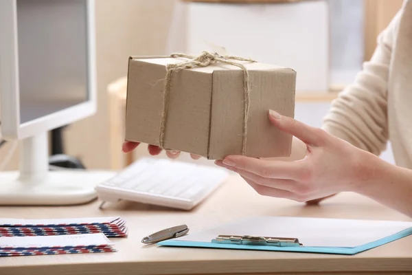 Frau gibt Paket in Postfiliale ab — Stockfoto