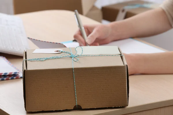 Cardboard boxes on work place in post office Stock Photo by ©belchonock