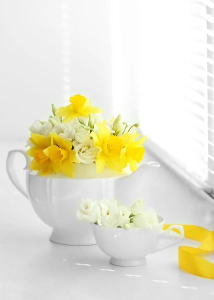 Mooi boeket rozen in theepot op de vensterbank of gele narcissen — Stockfoto