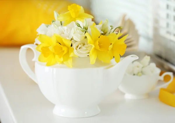 Beautiful bouquet of yellow daffodils and roses in teapot on windowsill — Stock Photo, Image