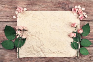 Ahşap masa, üstten görünüm üzerinde kağıt üzerine kurutulmuş güller